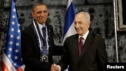 FILE - President Barack Obama shakes hands with Israeli President Shimon Peres after Peres presented him the Israeli Medal of Distinction in Jerusalem, Israel, March 21, 2013.