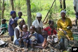 Women farmers take a break with their children in the village where they are part of a pioneering project to help control food production, as well as its distribution, and the use of the profits from their labor, in Naminya, Uganda, December 2011.