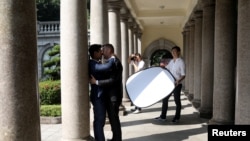 Lin Chinxuan, right, holds a reflector as Austin Haung, 32, photographs Kao Shaochun, left, and John Sugden during their pre-wedding photoshoot in Taipei, Taiwan, Nov. 11, 2018. Chinxuan and Haung are a couple and together they run Hiwow studio photographing LGBTQ couples.