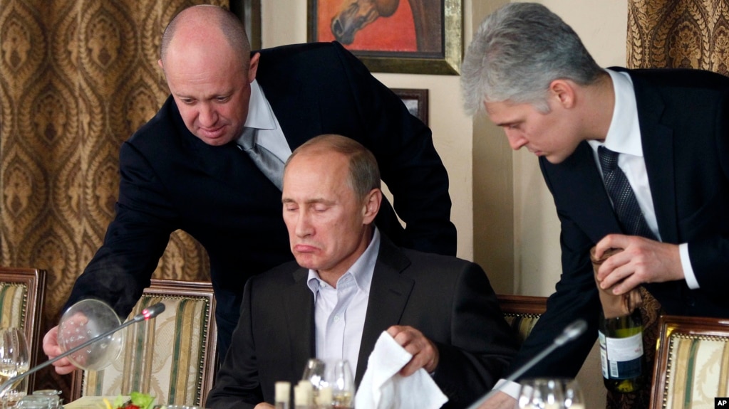 Предприниматель Евгений Пригожин (слева) обслуживает Владимира Путина в своем ресторане в пригороде Москвы