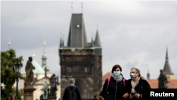 Para pejalan kaki mengenakan masker, melintasi Jembatan Charles abad pertengahan di tengah pandemi Covid-19 di Praha, Republik Ceko, 25 September 2020. (Foto: dok).