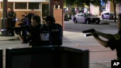 Dallas police move to detain a driver after several police officers were shot in downtown Dallas, July 7, 2016. 