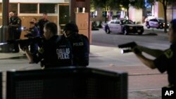 7일 미국 텍사스 주 댈러스에서 경찰의 흑인 총격 사망 사건에 항의하는 시위 도중 총격이 발생해 경찰관 5명이 숨진 가운데, 경찰관들이 용의자가 탄 것으로 보이는 차량을 향해 총을 겨누고 있다.