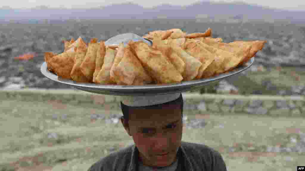 An Afghan samosa vendor looks on as he waits for customers at Wazir Akbar Khan hilltop overlooking Kabul on March 26, 2019.