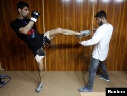 Fighters and team members prepare backstage before matches of a mixed martial arts competition in Kabul, Afghanistan, March 30, 2017.