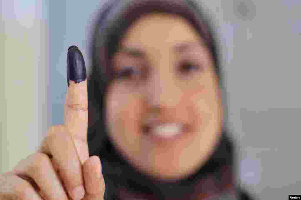 A woman shows her ink-stained finger after casting her vote during the National Assembly election in Benghazi July 7, 2012. Libyans, some with tears of joy in their eyes, queued to vote in their first free national election in 60 years on Saturday, a poll