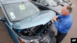 一名銷售經理打開一輛本田汽車的引擎蓋（2014年12月2日）