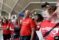 FILE -- Mark Jewell, president of the North Carolina Association of Educators asks teachers to refrain from chanting and causing a disturbance outside the House and Senate chambers during a teachers rally at the General Assembly in Raleigh, N.C., May 16, 2018.