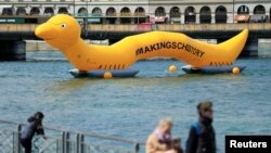 FILE - A giant 25m worm representing the parasitic worm of schistosomiasis, that causes significant suffering and death to thousands of people around the world, is pictured on the Lake Leman on the occasion of the Neglected Tropical Diseases Summit, in Geneva, Switzerland, April 18, 2017.