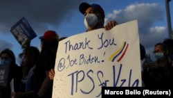 Seorang pria memegang poster bersama warga komunitas Venezuela menyusul pengumuman oleh pemerintahan Biden bahwa akan memberikan status perlindungan sementara (TPS) untuk migran Venezuela yang tinggal di AS, di Doral, Florida, 9 Maret 2021. (Foto: Reuters