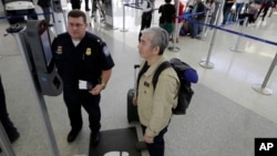 U.S. Customs and Border Protection supervisor Erik Gordon, left, helps a passenger navigate one of the new facial recognition kiosks at a United Airlines gate before boarding a flight to Tokyo, Wednesday, July 12, 2017, at George Bush Intercontinental Air