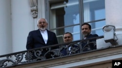 Iranian Foreign Minister Mohammad Javad Zarif (L) talks to journalist from a balcony of the Palais Coburg hotel where the Iran nuclear talks are being held in Vienna, Austria, July 9, 2015.