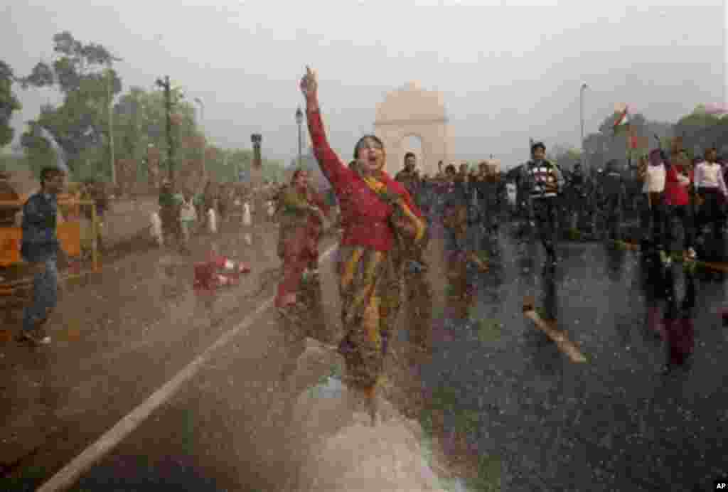 A female protester shouts as she is hit with an Indian police water cannon during a violent demonstration near the India Gate against a gang rape and brutal beating of a 23-year-old student on a bus last week, in New Delhi, India, Sunday, Dec. 23, 2012.