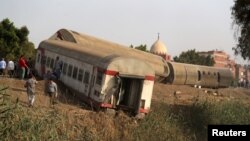 Masyarakat berkerumun di sekitar lokasi kereta api yang mengalami kecelakaan di provinsi Qalioubia, Utara Cairo, Mesir, 18 April 2021. (REUTERS/Mohamed Abd El Ghany)