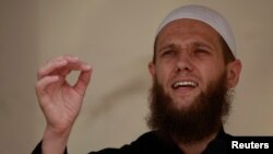 FILE - Islamist preacher Sven Lau delivers a speech during a pro-Islam demonstration in Cologne, Germany, June 9, 2012. 