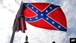FILE - A protester waves a Confederate battle flag in front of the South Carolina statehouse, July 9, 2015, in Columbia, South Carolina. 