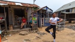 Un étudiant de la Leap of Dance Academy, Anthony Madu, effectue une routine de danse classique devant la boutique de sa mère dans la rue Okelola à Ajangbadi, Lagos, le 3 juillet 2020.
