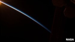FILE - Earth's thin atmosphere stands out against the blackness of space in this photo shared on Aug. 31, 2015, by NASA astronaut Scott Kelly on board the International Space Station. 