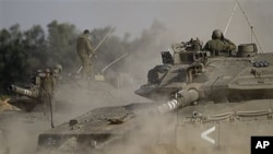 An Israeli tank drives next to the border between Israel and the southern Gaza Strip, April 8, 2011