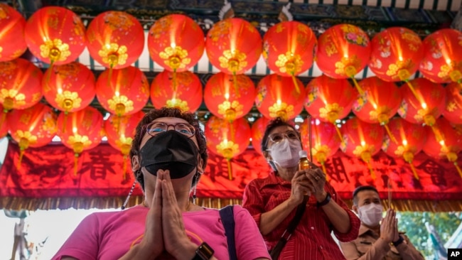 People pray for good fortune on the eve of the Lunar New Year at Tai Hong Kong Shrine in Bangkok, Thailand, Monday, Jan. 31, 2022. (AP Photo/Sakchai Lalit)