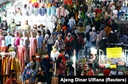 Para pengunjung tetap menggunakan masker saat berbelanja menjelang hari raya Idul Fitri di Pasar Tanah Abang di Jakarta Pusat pada 3 Mei 2021. (Foto: Reuters/Ajeng Dinar Ulfiana)