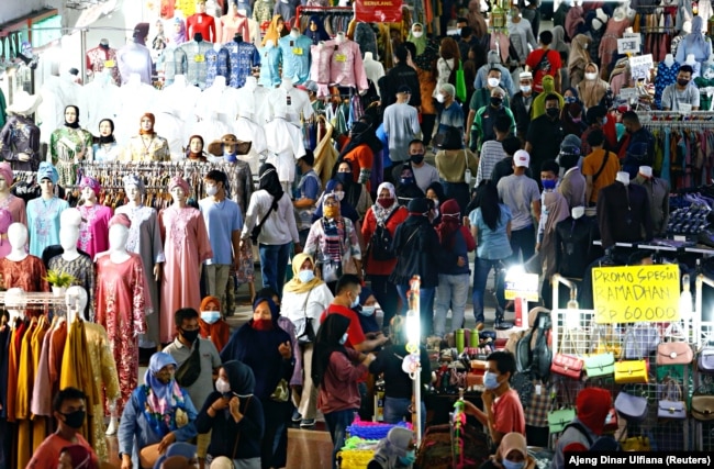 Para pengunjung tetap menggunakan masker saat berbelanja menjelang hari raya Idul Fitri di Pasar Tanah Abang di Jakarta Pusat pada 3 Mei 2021. (Foto: Reuters/Ajeng Dinar Ulfiana)