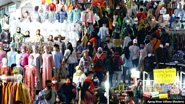 Para pengunjung tetap menggunakan masker saat berbelanja menjelang hari raya Idul Fitri di Pasar Tanah Abang di Jakarta Pusat pada 3 Mei 2021. (Foto: Reuters/Ajeng Dinar Ulfiana)