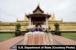 U.S. Secretary of State John Kerry signs the guest book after visiting the That Luang Stupa -- the most revered Buddhist temple in Laos -- following meetings with government leaders in Vientiane, Laos, Jan. 25, 2016.