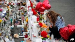 Gloria Garcés se arrodilla frente a las cruces en un monumento improvisado cerca de la escena de un tiroteo masivo en un complejo comercial el martes 6 de agosto de 2019 en El Paso, Texas. (Foto AP / John Locher).