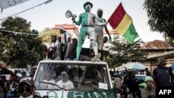 Les partisans du principal candidat de l'opposition, Cellou Dalein Diallo, se tiennent sur une camionnette lors d'un rassemblement électoral, à Conakry le 14 octobre 2020.
