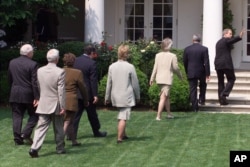 FILE - President George W. Bush waves as he is followed by members of his cabinet after he spoke on global warming in the Rose Garden of the White House, June 11, 2001. Two decades ago, the leading U.S. Senate proponent of taking action on global warming was Republican John McCain. Bush wasn't as zealous on the issue as his Democratic opponent for president in 2000, Al Gore, but he, too, talked of regulating carbon dioxide.