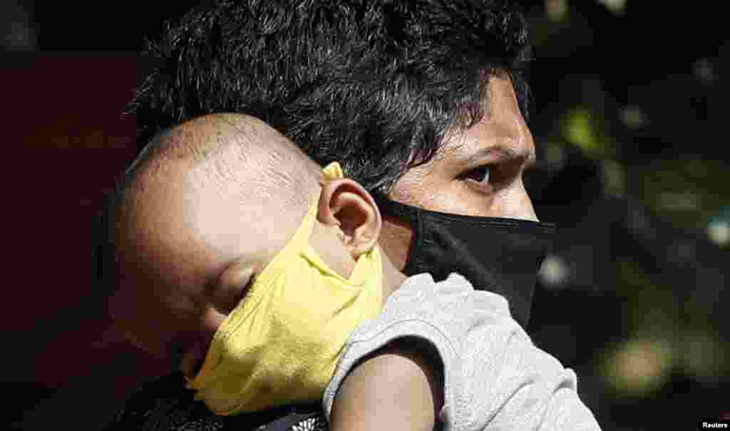 بھارت کے شہر ممبئی میں بھی کرونا وائرس سے بچنے کے لیے گود کے بچوں کو بھی ماسک پہنائے جا رہے ہیں۔