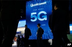 FILE - A sign advertises 5G at the Qualcomm booth at CES International in Las Vegas, Jan. 9, 2019.