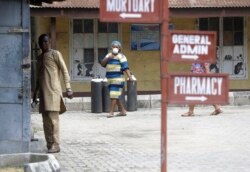 People walk inside the Yaba Mainland hospital compound where an Italian citizen who entered Nigeria on Tuesday from Milan on a business trip, the first case of the COVID-19 virus is being treated in Lagos Nigeria Friday, Feb. 28, 2020. (AP Photo)