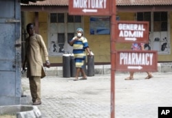 People walk inside the Yaba Mainland hospital compound where an Italian citizen who entered Nigeria on Tuesday from Milan on a business trip, the first case of the COVID-19 virus is being treated in Lagos Nigeria Friday, Feb. 28, 2020. (AP Photo)