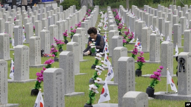 2019年6月6日，一名韩国妇女在韩国首尔的国家公墓，在韩战中牺牲的亲戚墓前祈祷。