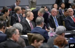 Russian President Vladimir Putin, center left, listens to his adviser Yuri Ushakov, center right, as U.S. Vice President Mike Pence, right, looks on, during the ASEAN summit in Singapore, Nov. 15, 2018.