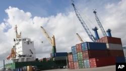 Shipping containers beside a cargo ship at the Port of Miami, Fla., Feb. 4, 2011 (file photo).