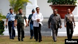 New Indonesian President Joko Widodo walks with heads of the military, police and intelligence to address the media at the presidential palace in Jakarta, Oct. 22, 2014.