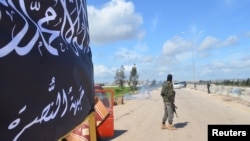 FILE - Members of al-Qaida's Nusra Front man a checkpoint in Idlib.