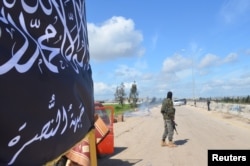FILE - Members of the al-Nusra Front man a checkpoint in Idlib.