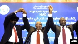 FILE - Sudanese President Omar al-Bashir (C) raises held hands with South Sudan's President Salva Kiir Mayardit (L) and South Sudanese rebel leader Riek Machar (R) after the two South Sudanese arch-foes agreed in Khartoum, June 27, 2018, to a "permanent" cease-fire.