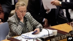 FILE - Hillary Clinton, who at the time was U.S. secretary of state, checks her mobile phone after speaking to the U.N. Security Council in New York, March 12, 2012. 