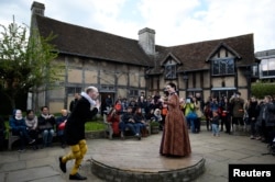 Tourists watch actors perform at the house where William Shakespeare was born. The celebration in Stratford-Upon-Avon, Britain was held on April 23, 2016. It marked the 400th anniversary of the playwright's death. (REUTERS PHOTO/Dylan Martinez)