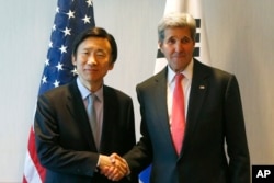 U.S. Secretary of State John Kerry, right, and South Korea's Foreign Minister Yun Byung-se shake hands during a meeting in Munich, Germany, prior to the start of the Munich Security Conference, Feb. 12, 2016.
