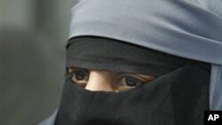 A woman dressed in a niqab, speaks with reporters during a press conference in Montreuil, east of Paris, 18 May 2010