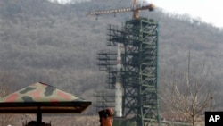 A North Korean soldier stands in front of the country's Unha-3 rocket, slated for liftoff between April 12-16, at Sohae Satellite Station in Tongchang-ri, North Korea on Sunday April 8, 2012. North Korean space officials have moved a long-range rocket int
