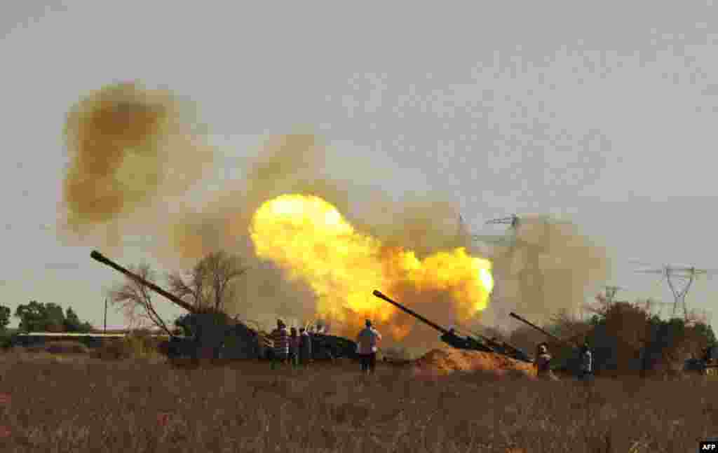 Revolutionary fighters fire canons toward pro-Gadhafi forces from the western outskirts of Sirte, Libya Wednesday, Sep. 21, 2011. (AP Photo/Gaia Anderson)