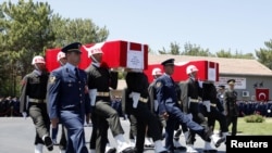 Turkish soldiers carry the coffins of fallen Turkish pilots, Captain Gokhan Ertan and Lieutenant Hasan Huseyin Aksoy, during an official farewell ceremony at the 7th Jet Main Air Base in the eastern Turkish city of Malatya July 6, 2012.