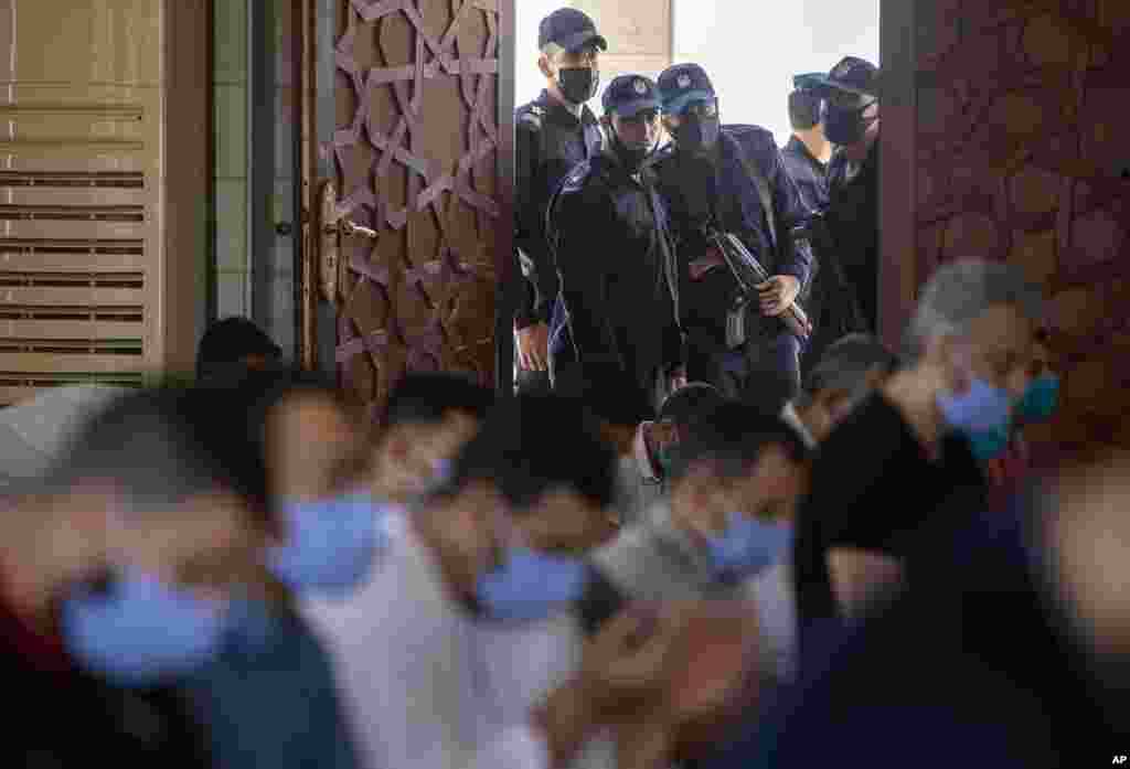 Palestinian Hamas police stand guard at the entrance of a mosque as worshipers attend the last Friday noon Prayer of the holy month of Ramadan, in Gaza City.